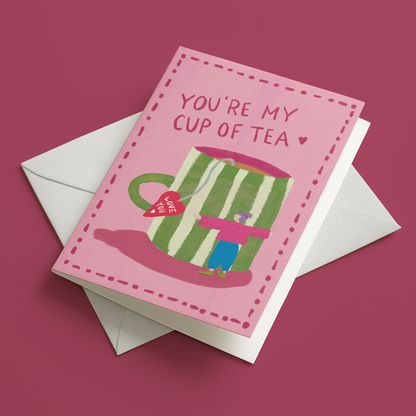 You’re My Cup of Tea illustrated greeting card mockup photographed at an angle on two white envelopes on a pink background